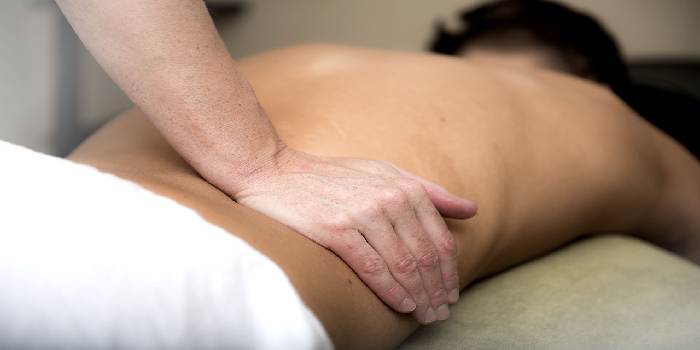 fisioterapista che massaggia un paziente
