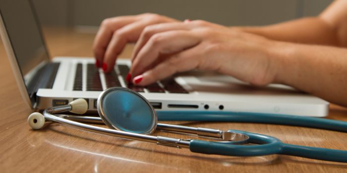 pediatra che scrive a pc e strumento medico vicino