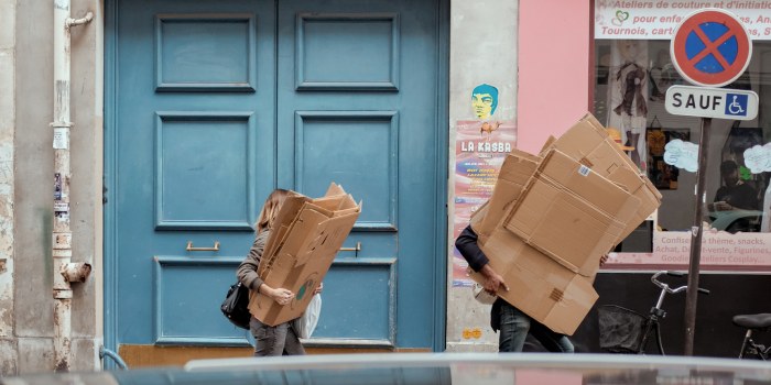 due persone con scatoloni che fanno il trasloco